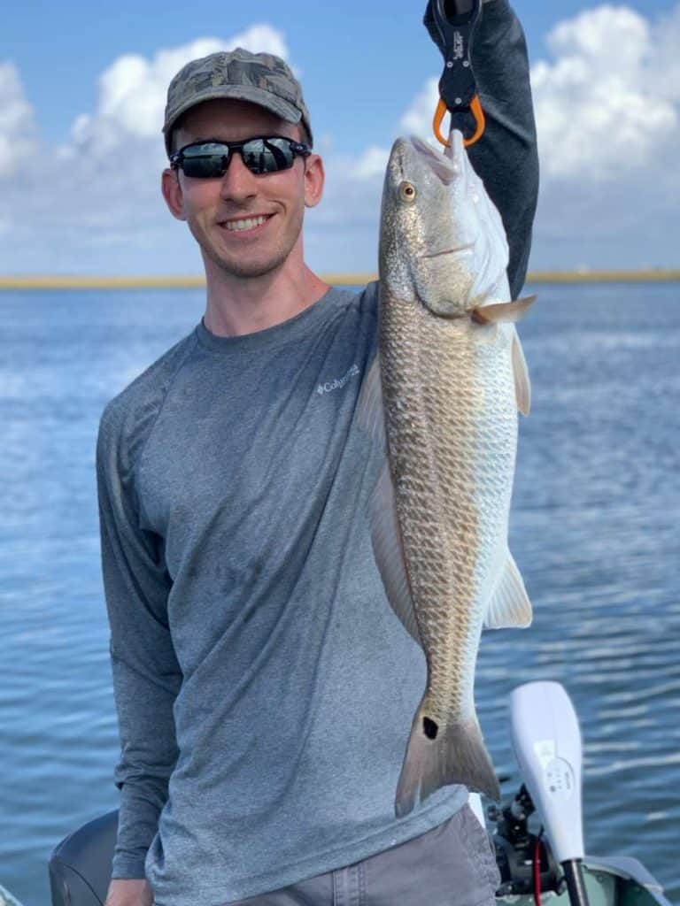 andrew juran holding-redfish-with-fishing-shirt