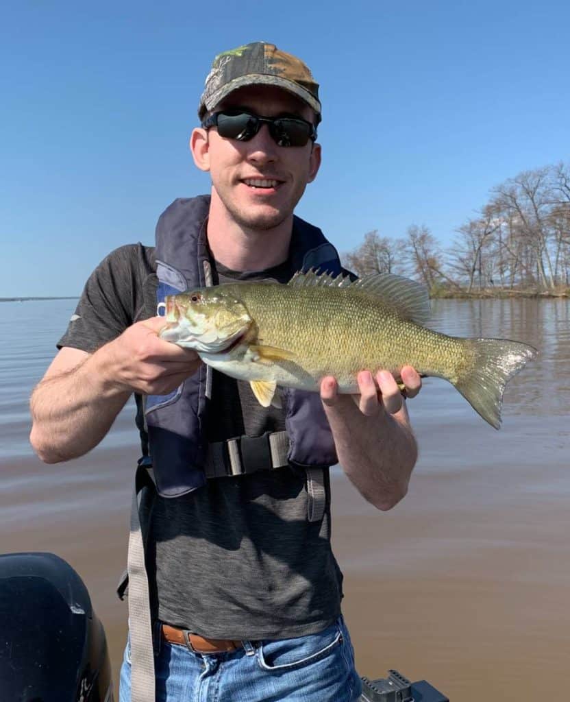 andrew juran holding pale smallmouth bass on chequamegon bay
