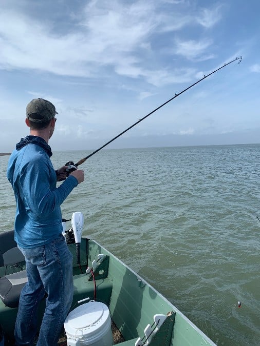 andrew juran reeling in fish on boat