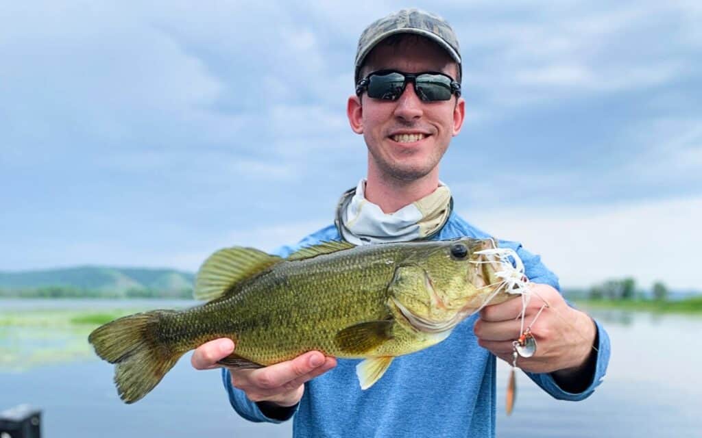 andrew juran holding largemouth bass caught with spinnerbait