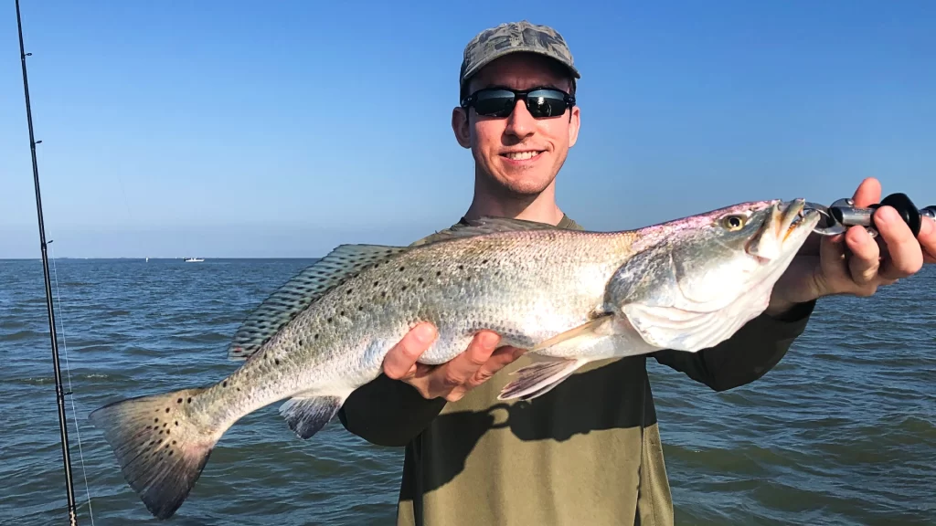 andrew juran holding speckled trout caught with daiwa rod and penn battle III reel