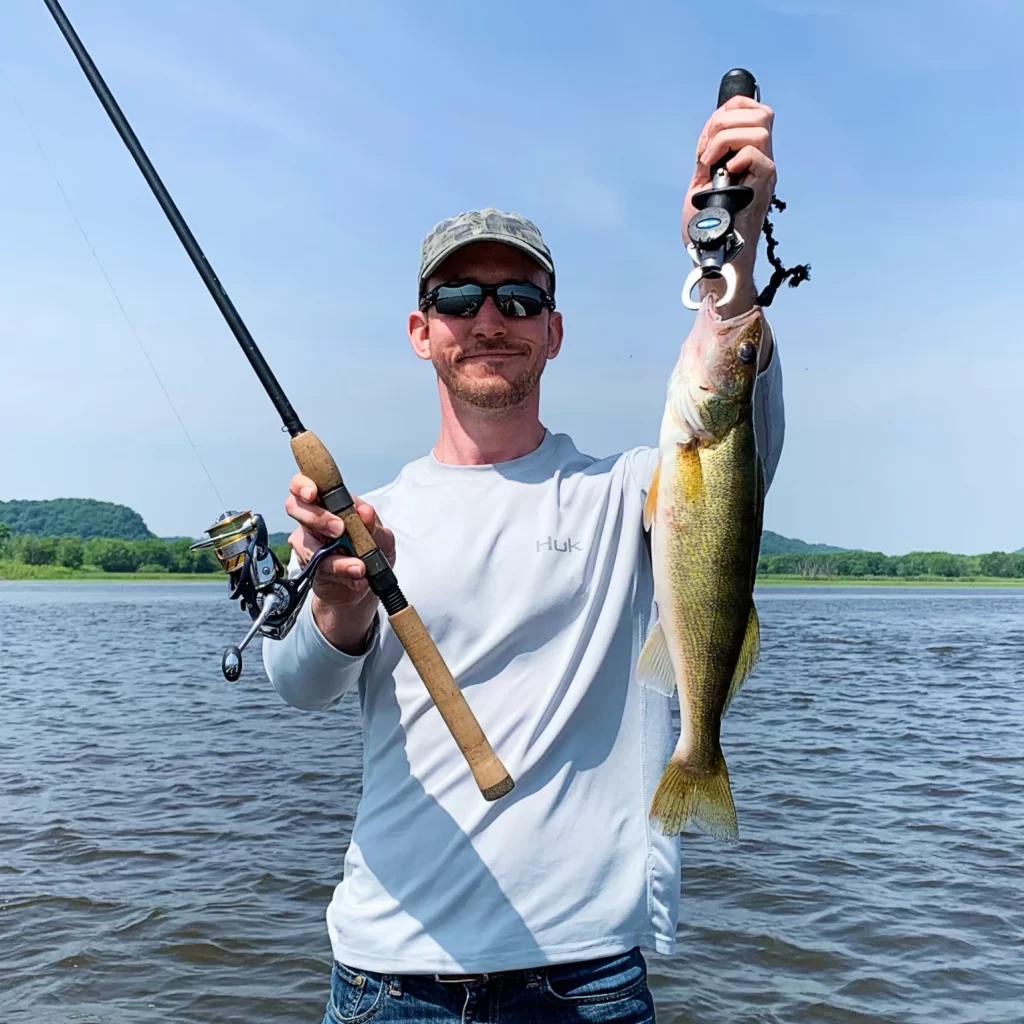 andrew juran holding st croix premier spinning rod and walleye fish
