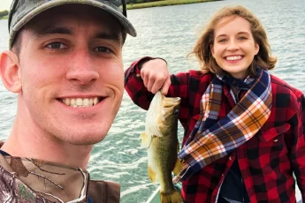 andrew juran and ornella juran bass fishing on a small boat holding a bass