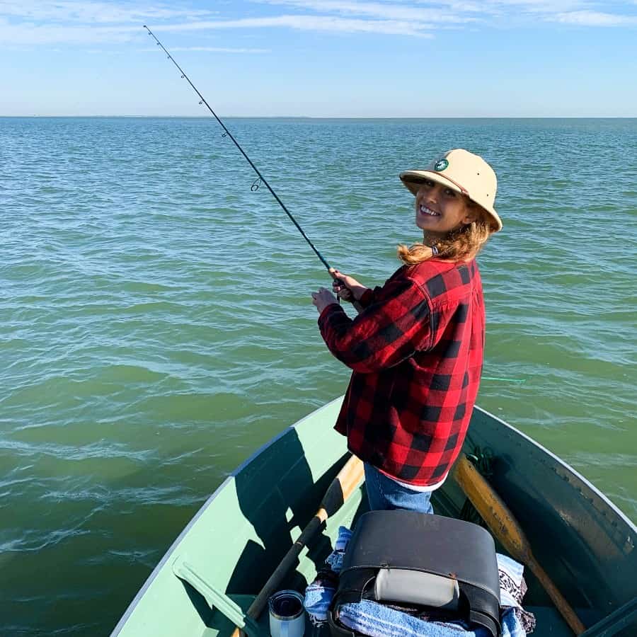 ornella juran fishing on a boat in red plaid jacket