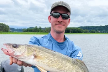 Andrew Juran Holding a walleye on a boat on the mississippi river