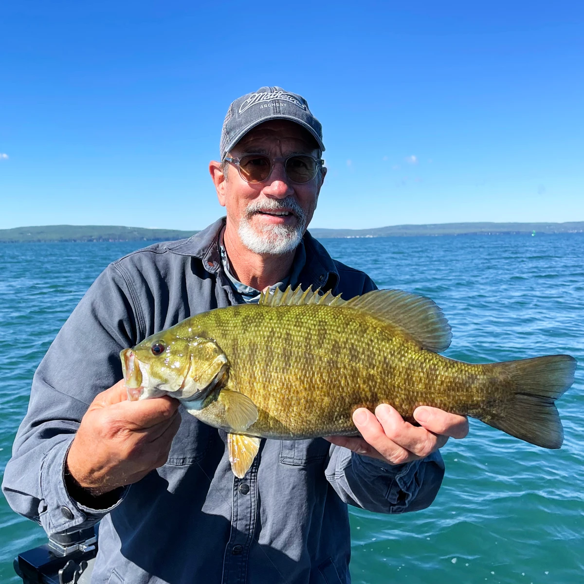 papa juran holding a smallmouth bass fishing on lake superior