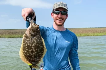 andrew juran holding flounder caught inshore fishing on small boat