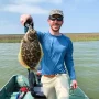 andrew juran holding flounder caught inshore fishing on small boat