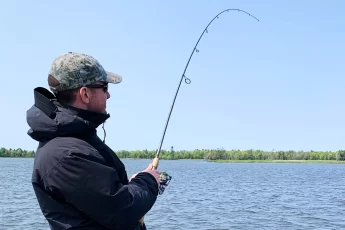 andrew juran holding Medium power st croix fishing rod with fast action bent over under stress while reeling in a fish