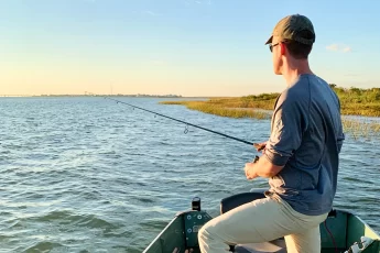 andrew juran fishing out of a small boat during sunrise with a spinning rod